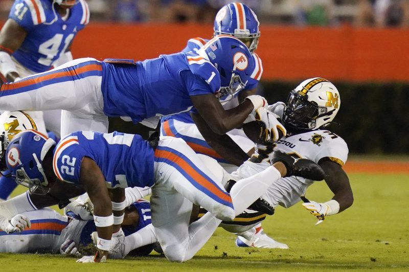 Missouri running back Larry Rountree III, right, is stopped by the Florida defense, including linebacker Brenton Cox Jr. (1) and defensive back Brad Stewart Jr., back, during the first half of an NCAA college football game Saturday, Oct. 31, 2020, in Gainesville, Fla. (AP Photo/John Raoux)