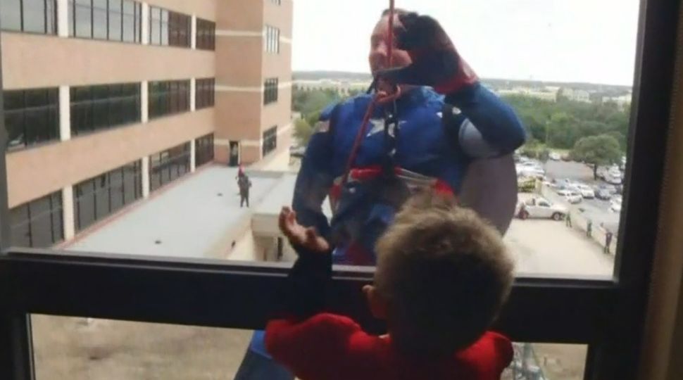 SAPD officer dressed as Captain America interacts with a child at North Central Baptist Hospital October 31, 2018 (Spectrum News)