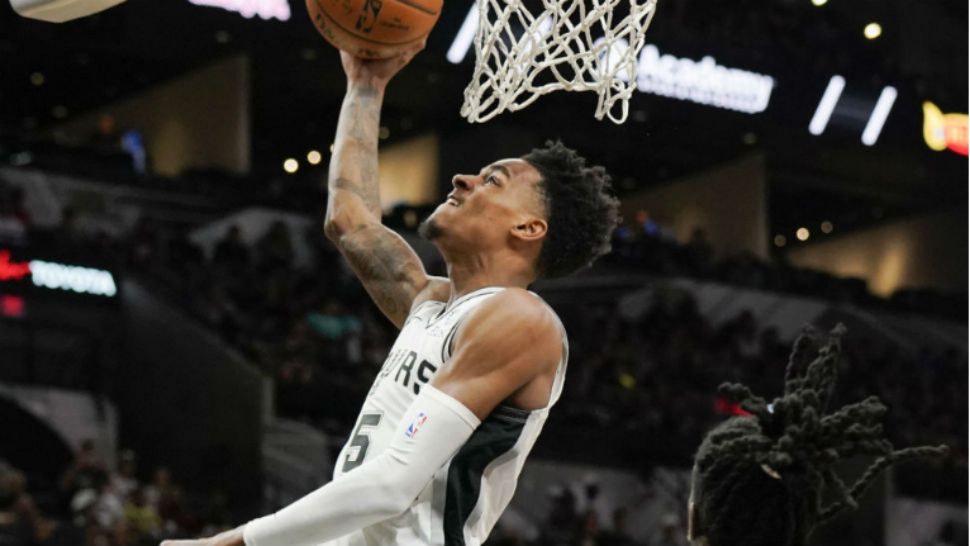 San Antonio Spurs' Dejounte Murray, left, shoots as Miami Heat's Briante Weber looks on during the second half of an NBA preseason basketball game, Sunday, Sept. 30, 2018, in San Antonio. San Antonio won 104-100. (AP Photo/Darren Abate)