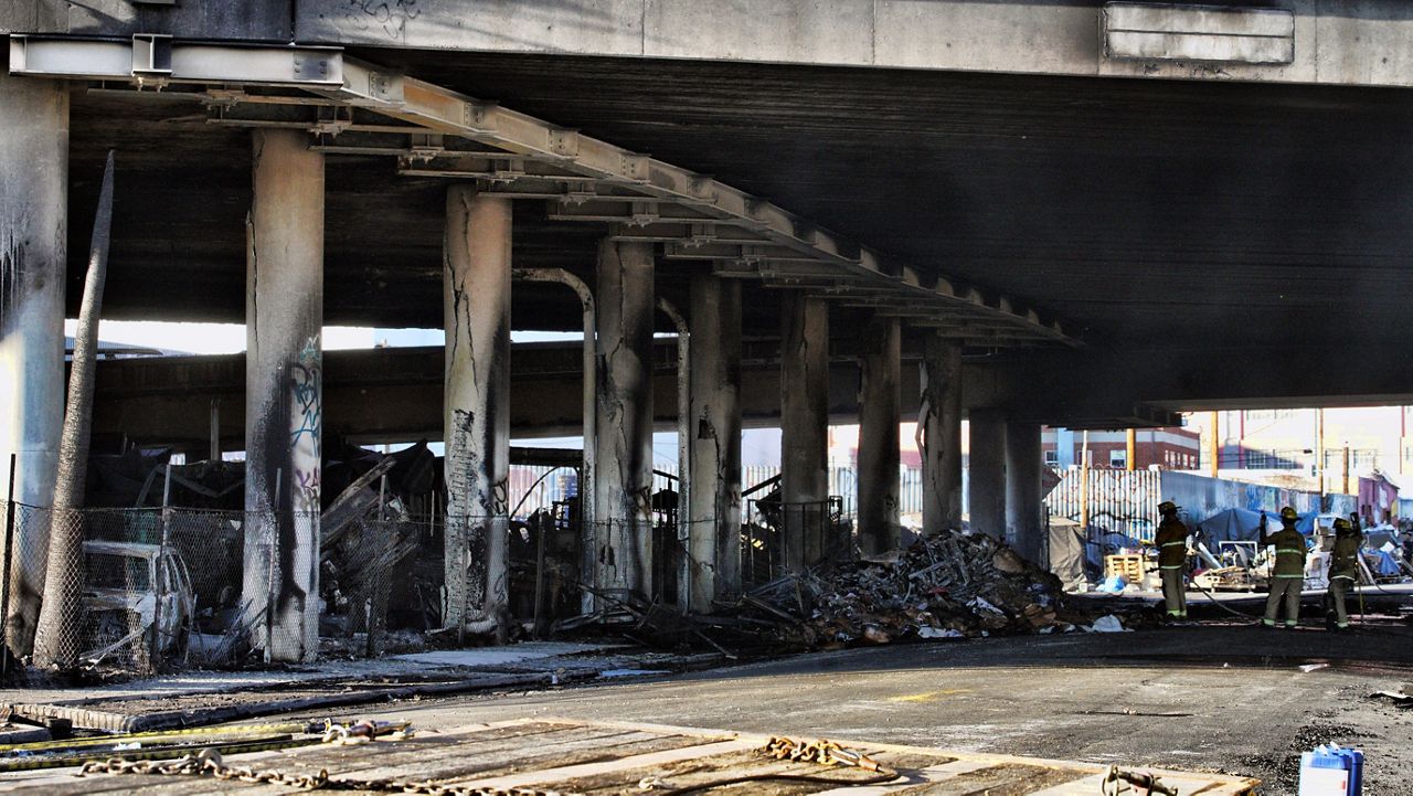 Los Angeles firefighters mop up from a fire under Interstate 10 that severely damaged the freeway in an industrial zone near downtown LA on Saturday. (AP Photo/Richard Vogel)