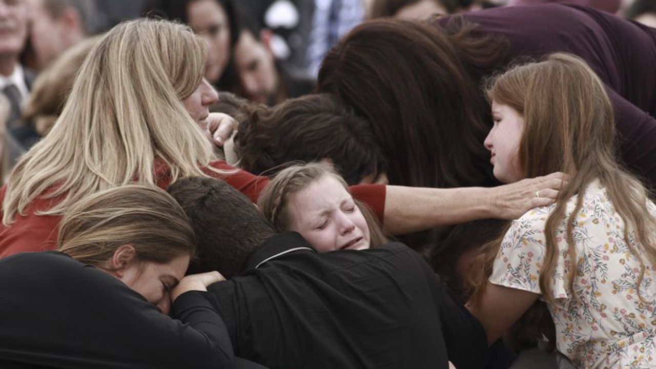 Family and friends weep during the funeral service for Dawna Ray Langford, 43, and her sons Trevor, 11, and Rogan, 2, who were killed in an ambush earlier this week, in La Mora, Mexico, Thursday, Nov. 7, 2019. As Mexican soldiers stood guard, the three were laid to rest in a single grave at the first funeral for the victims of a drug cartel ambush that left nine American women and children dead. (AP Photo/Christian Chavez)