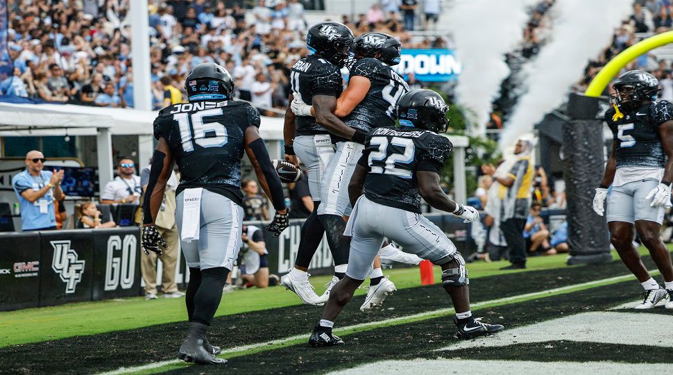 Central Florida quarterback Jacurri Brown, center left, celebrates with team mates after running the ball for a touchdown against Arizona during the first half in an NCAA college football game, Saturday, Nov. 2, 2024, in Orlando, Fla. (AP Photo/Kevin Kolczynski)