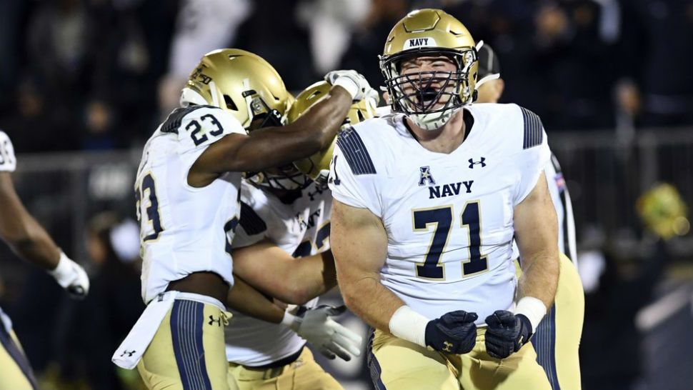 Navy offensive tackle Billy Honaker (71) screams after wide receiver Mychal Cooper scored during the first half of an NCAA college football game against Connecticut on Friday, Nov. 1, 2019, in East Hartford, Conn. (AP Photo/Stephen Dunn)