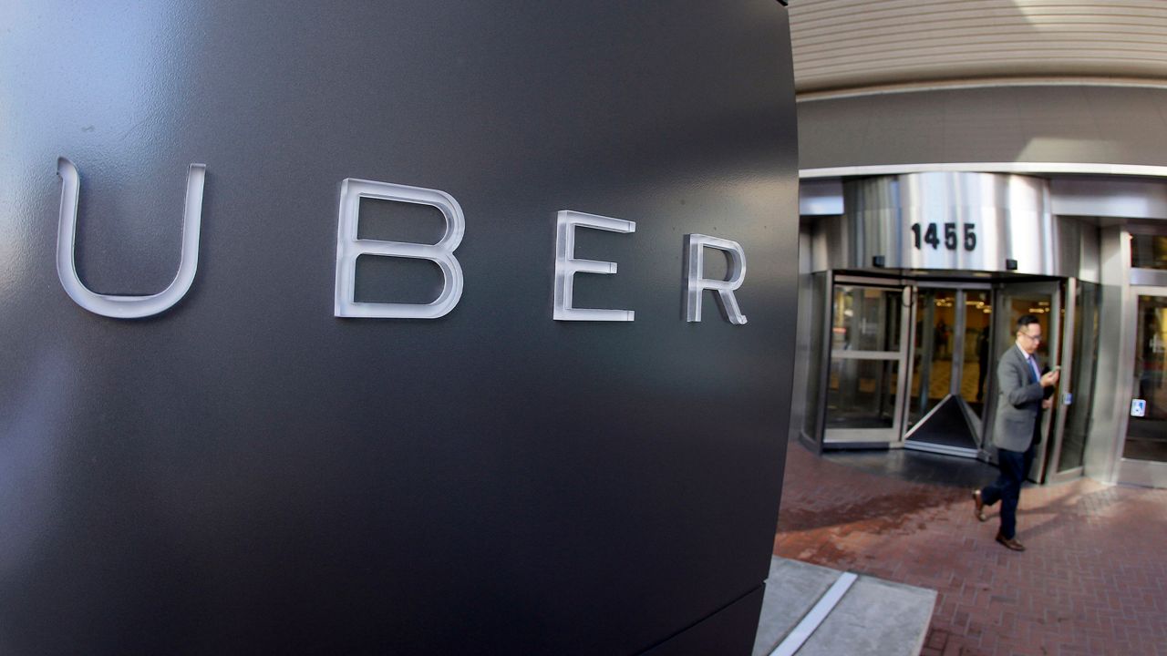 In this Dec. 16, 2014, file photo a man leaves the headquarters of Uber in San Francisco.  (AP Photo/Eric Risberg, File)