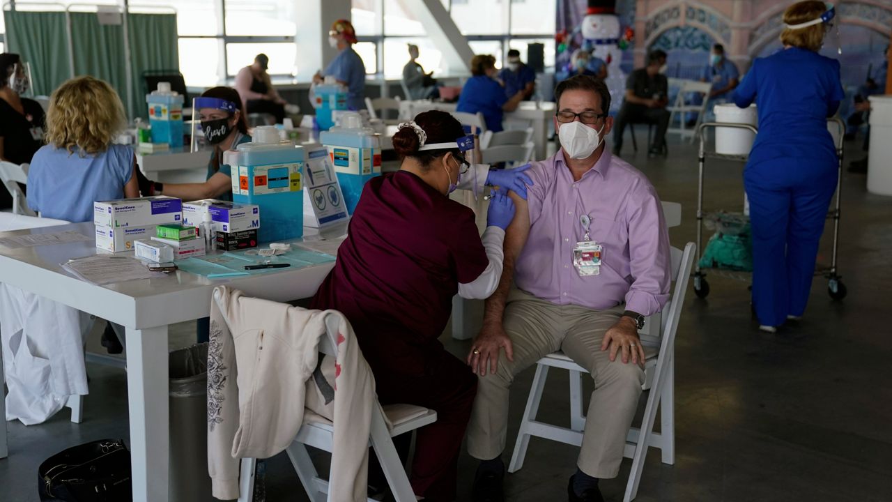 Dr. Michael Forino, right, gets the Pfizer-BioNTech COVID-19 vaccine at St. Joseph Hospital in Orange, Calif., Thursday, Jan. 7, 2021. (AP Photo/Jae C. Hong)
