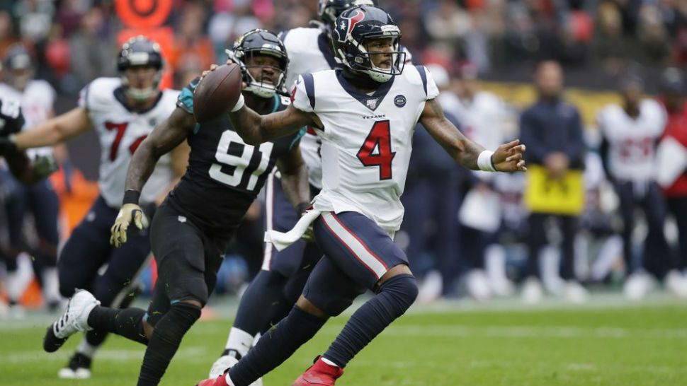 Houston Texans quarterback Deshaun Watson (4) runs out of the pocket under pressure by Jacksonville Jaguars defensive end Yannick Ngakoue (91) during the first half of an NFL football game at Wembley Stadium, Sunday, Nov. 3, 2019, in London. (AP Photo/Kirsty Wigglesworth)