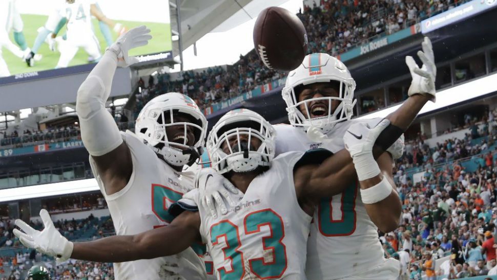 Miami Dolphins' outside linebacker Jerome Baker (55) cornerback Jomal Wiltz (33) and defensive back Nik Needham (40) celebrate after Wiltz made an interception during the first half of an NFL football game against the New York Jets, Sunday, Nov. 3, 2019, in Miami Gardens, Fla. (AP Photo/Lynne Sladky)