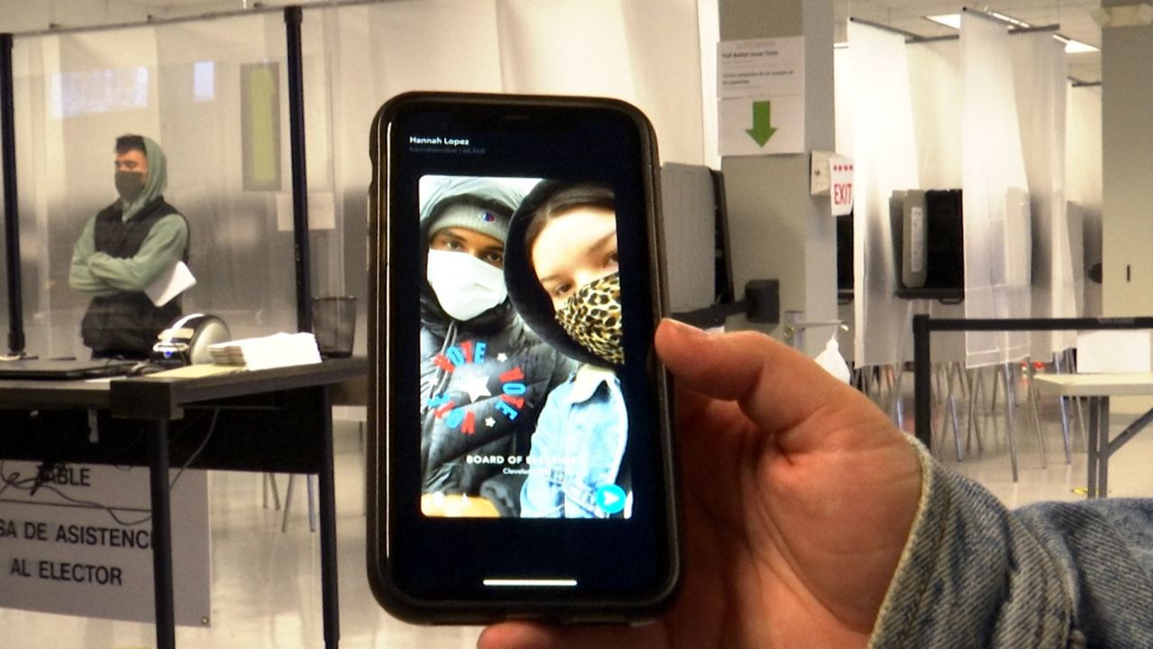 A phone with a photo of two people in masks