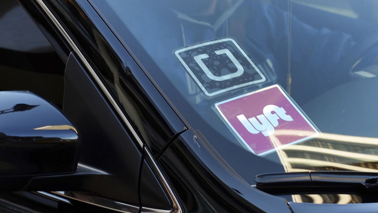 A ride share car displays Lyft and Uber stickers on its front windshield in downtown Los Angeles on Jan. 12, 2016. (AP Photo/Richard Vogel, File)
