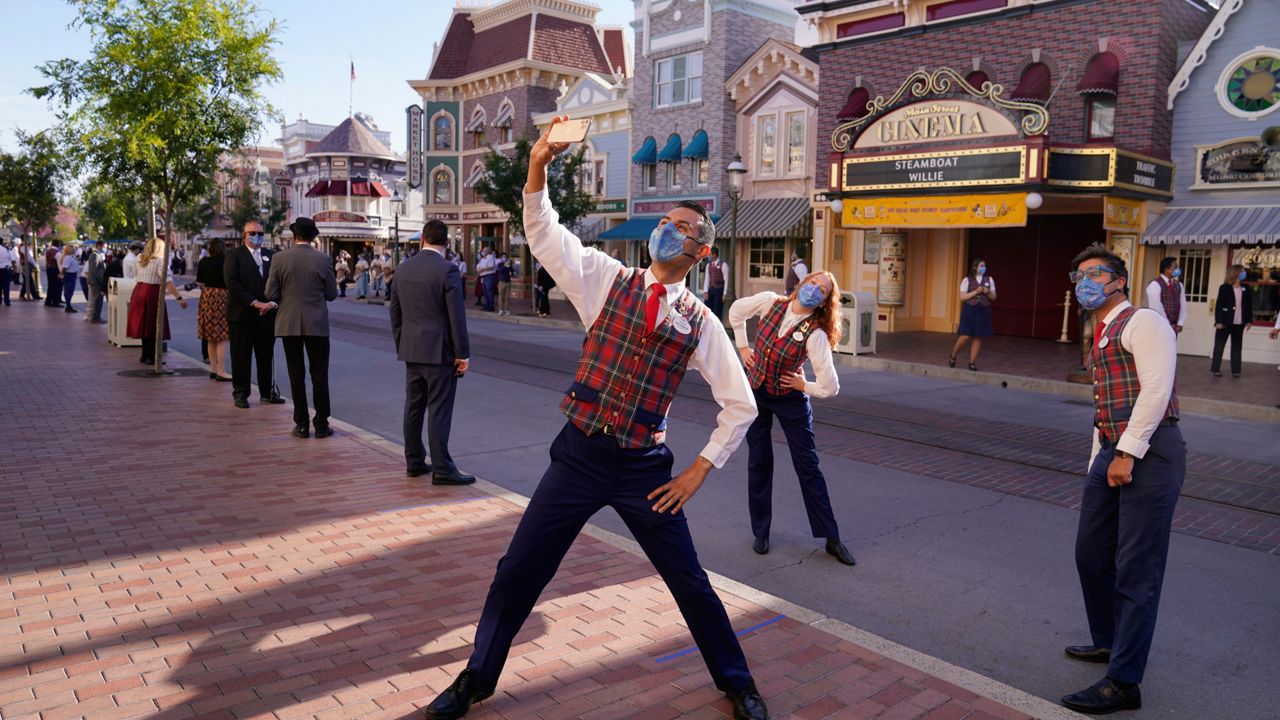 Employees take a photo on Main Street before the gates open at Disneyland in Anaheim, Calif., Friday, April 30, 2021. (AP Photo/Jae Hong)