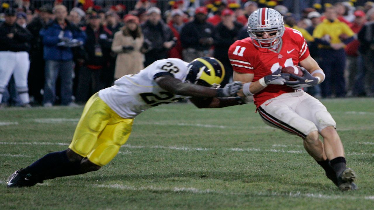 A Michigan football player attempts to tackle an Ohio State player