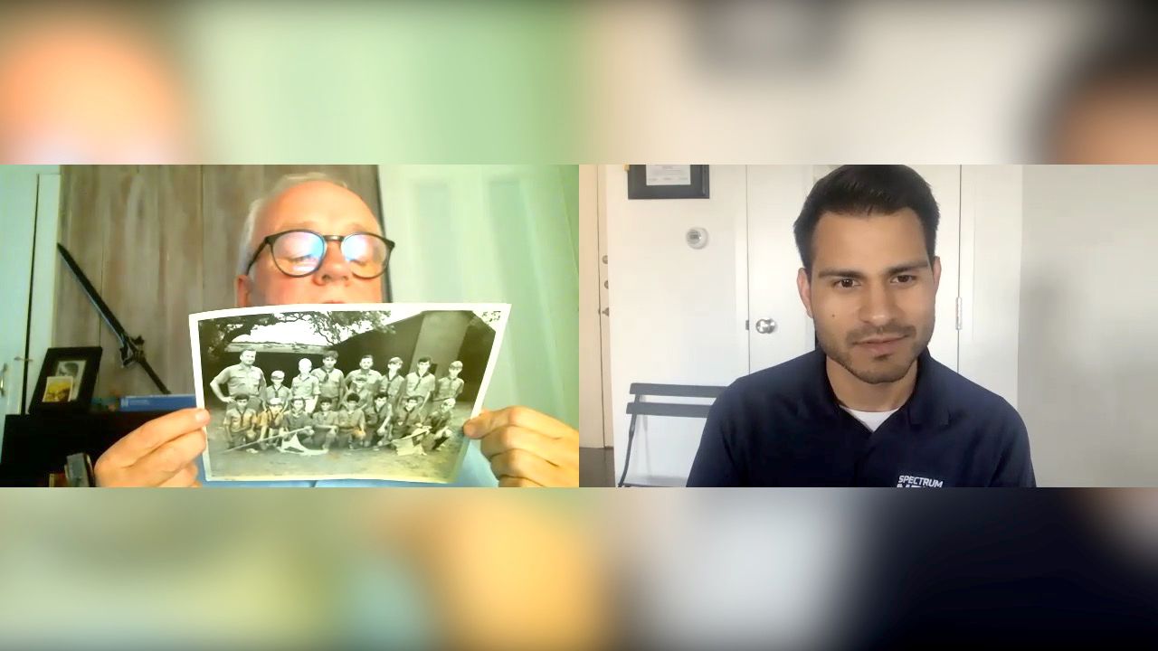 John Litton holds up a Boy Scouts photo during a Zoom call with reporter Lupe Zapata where he identifies the scoutmaster who abused him (Spectrum News)
