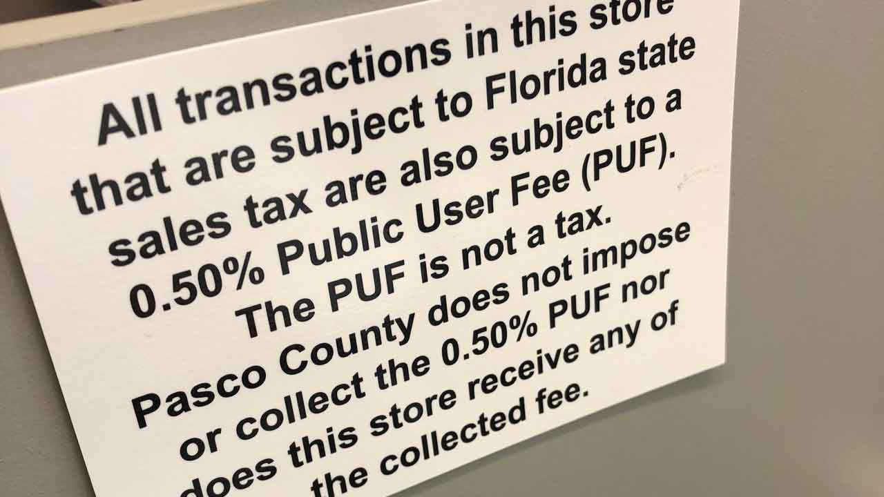 Sign posted at a merchant in the Cypress Creek Town Center in Pasco County informing customers that they will be charged a "public user fee" on any transactions in the store, and that neither the county nor the store collect revenue from the fee. (Tim Wronka/Spectrum Bay News 9)