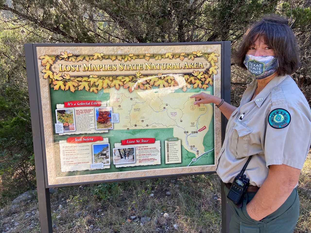 Lisa Fitzsimmons, superintendent at Lost Maples State Natural Area, points at the map of the park (Spectrum News)