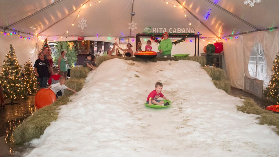 A child slides down man-made snow. (Spectrum News photograph)