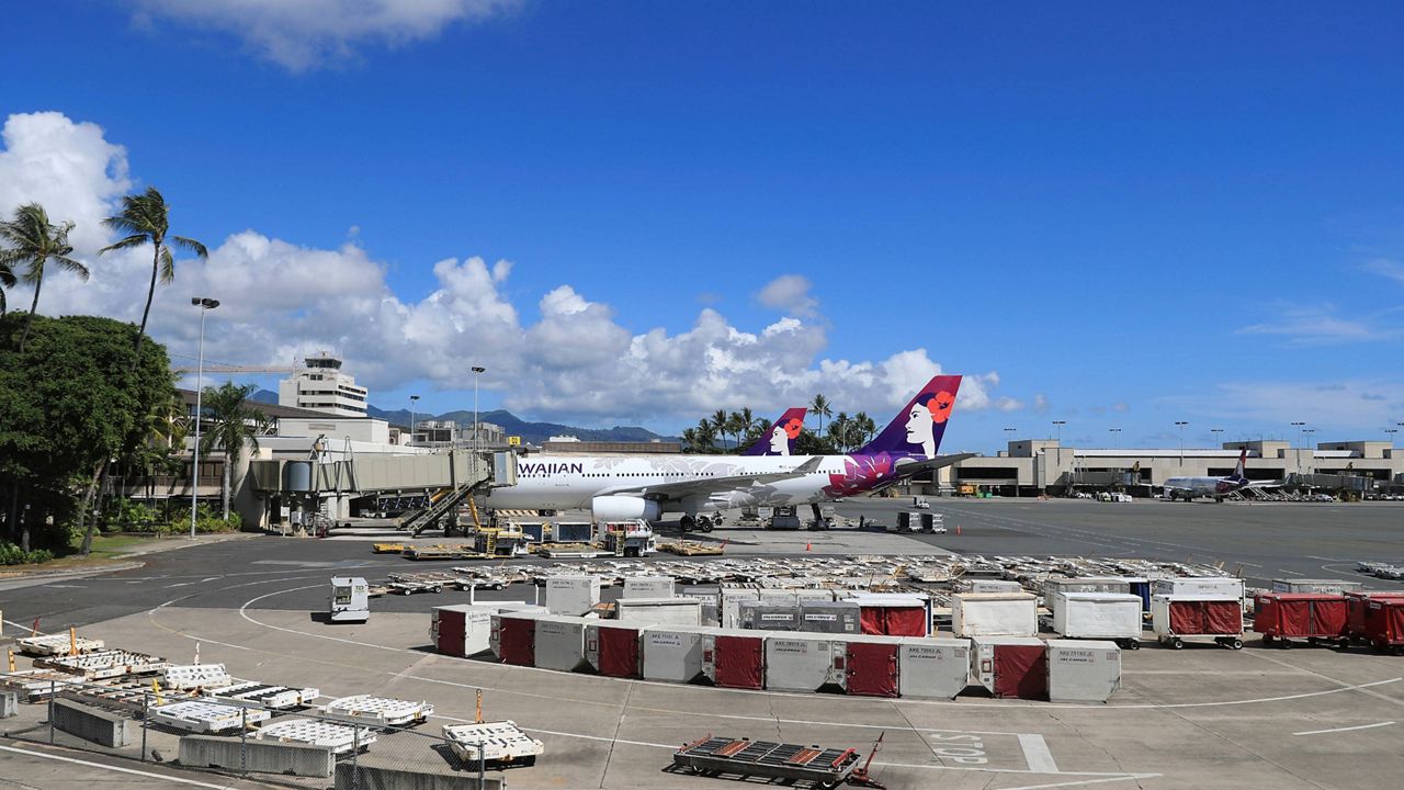 An airplane is seen parked at a terminal at the the Daniel K. Inouye International Airport (AP Photo/Marco Garcia)