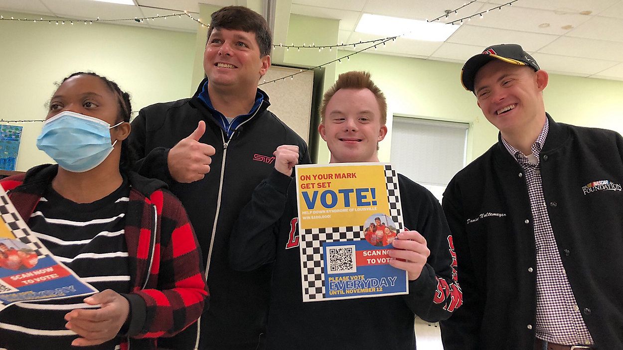 Jeff Harmon (with thumbs up) and Daniel Noltemeyer (far right) pose for a picture before learning Harmon won The NASCAR Foundation's annual humanitarian award. (Spectrum News 1 KY/Eileen Street)