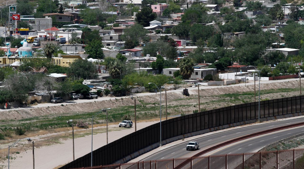 In this April 22, 2020, file photo a residential neighborhood of Juarez, Mexico, and U.S. Border Patrol vehicles on both sides of a border fence as seen from El Paso Texas. (AP Photo/Cedar Attanasio, File)