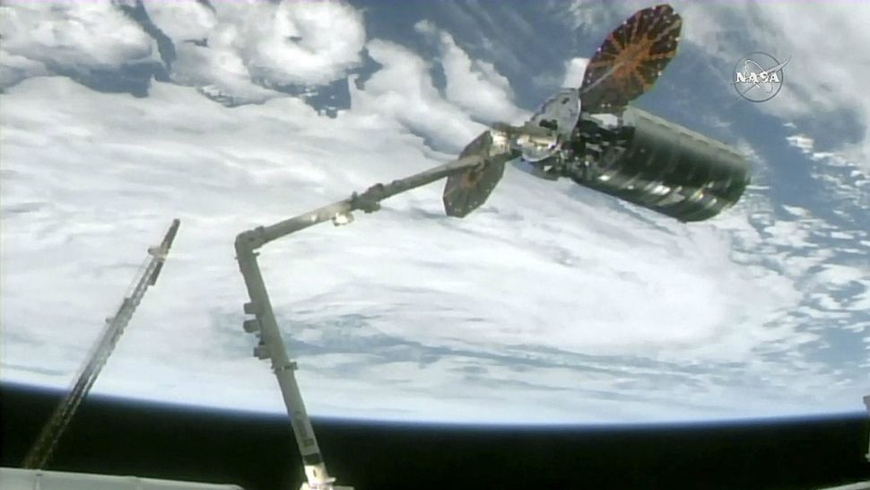 The International Space Station's robotic arm captures the Cygnus cargo spacecraft, Tuesday, Nov. 14, 2017, 260 miles above the earth. The commercial supply ship arrived at the International Space Station on Tuesday, two days after launching from Virginia (NASA TV via AP)