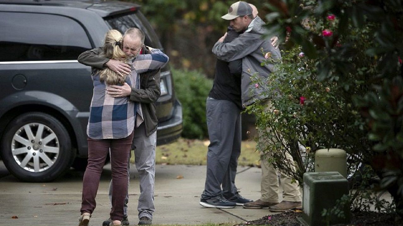 Neighbors console each other on Lord Granville Way in Rolesville, N.C., on Thursday, Nov. 12, 2020, after a neighborhood child drowned in a nearby flooded creek following heavy rains, according to The News & Observer. (Robert Willett/The News & Observer via AP)