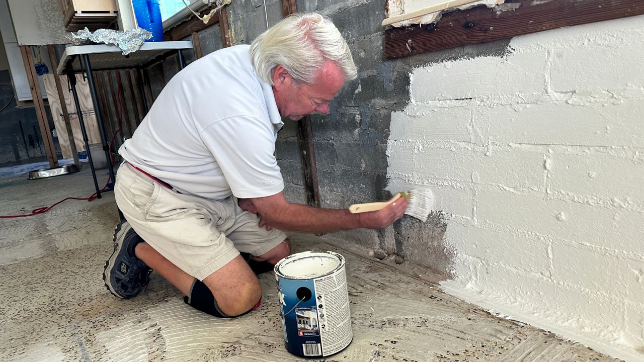 Storm prepper Jeff Fuller paints the interior block wall of his Redington Shores home with  Drylock Extreme, a waterproofing membrane (photo: Josh Rojas).