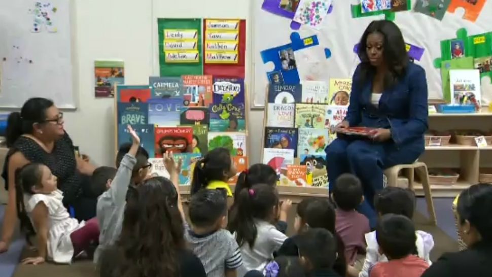 Former first lady Michelle Obama reads to schoolchildren at a school in Los Angeles. (Chelsea Washington/Spectrum News 1)