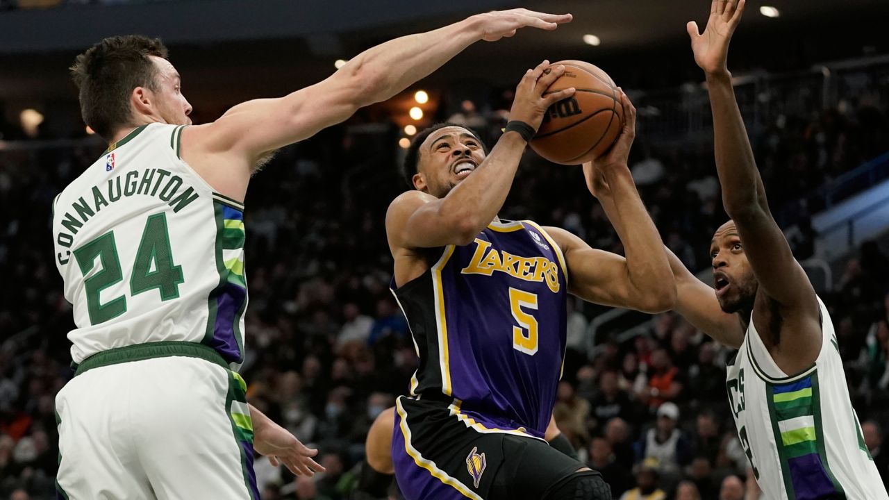 Los Angeles Lakers' Talen Horton-Tucker drives between Milwaukee Bucks' Pat Connaughton and Khris Middleton during the first half of an NBA basketball game Wednesday, Nov. 17, 2021, in Milwaukee. (AP Photo/Morry Gash)