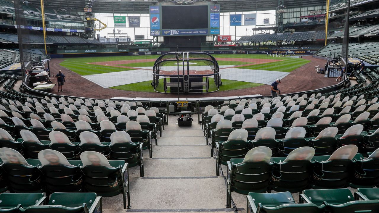 FILE - In this Friday, July 31, 2020, file photo, fan cutouts sit in seats behind home plate at Miller Park after it was announced that the baseball game between the Milwaukee Brewers and Cardinals in Milwaukee, was postponed after two Cardinals employees tested positive for the coronavirus. One more player and three staff members with the Cardinals have tested positive for the coronavirus, leading to the postponement of their game on Saturday against the Brewers, according to a person familiar with the situation. (AP Photo/Morry Gash, File)