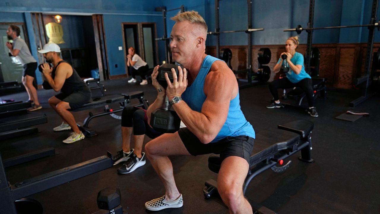Scott Johnson, foreground in blue, participates in a fitness class at Lift Society Friday, May 21, 2021, in Studio City, Calif. (AP Photo/Marcio Jose Sanchez)
