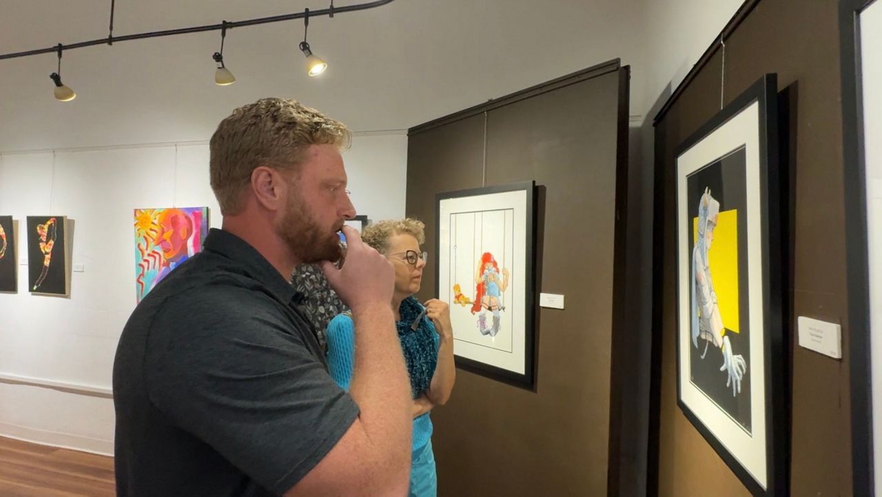 Ben Ruzicka shows his art to visitors at ArtCenter Manatee. (Spectrum Bay News 9/Julia Hazel)