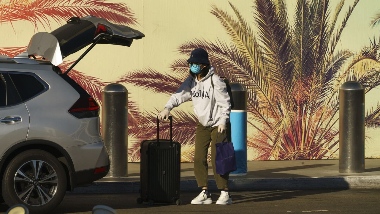 A traveler wears a face mask and gloves at Los Angeles International Airport in Los Angeles on Nov. 13, 2020. (AP Photo/Damian Dovarganes, File)