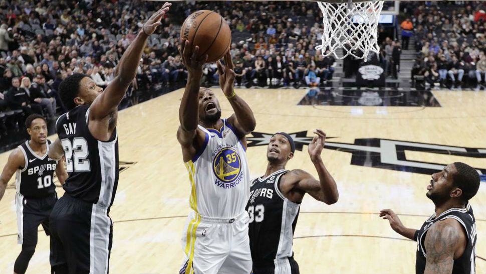 Golden State Warriors forward Kevin Durant (35) drives to the basket past San Antonio Spurs forward Rudy Gay (22) and forward Dante Cunningham (33) during the first half of an NBA basketball game Sunday, Nov. 18, 2018, in San Antonio. (AP Photo/Eric Gay)