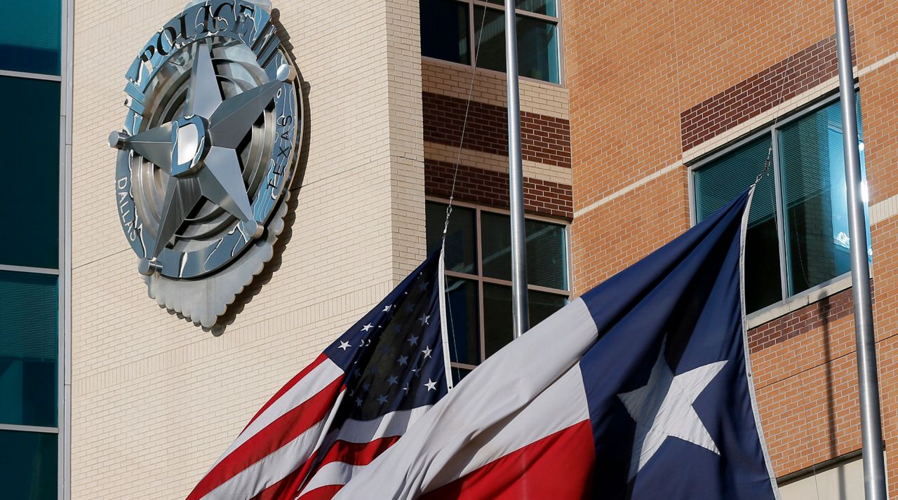 The American and Texas flag sit at half-staff outside of the Dallas police department headquarters, Friday, July 8, 2016, in Dallas. (AP Photo/Tony Gutierrez)