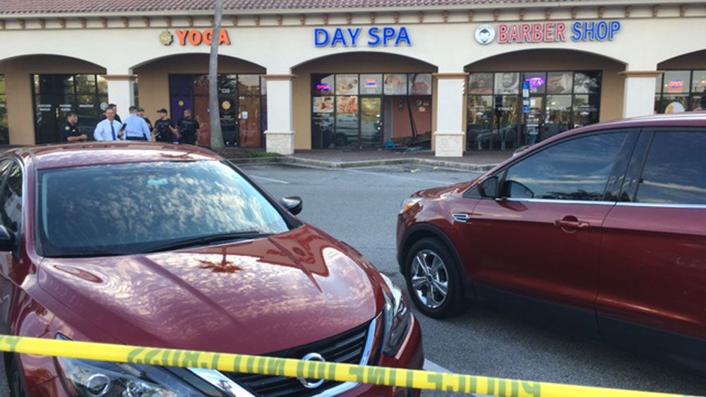 Orlando police say a man accused of stealing a car backed up into a day spa at a Universal Boulevard shopping complex to try to flee police. (Jeff Allen, Spectrum News)