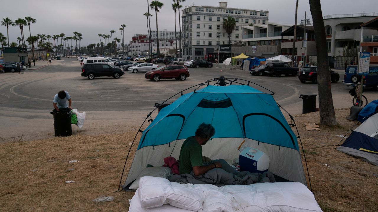 Jose Formoso, who said he moved from Malibu, Calif., after his RV burned down, sits in his tent near the boardwalk in the Venice neighborhood of Los Angeles, Tuesday, June 29, 2021. (AP Photo/Jae C. Hong)