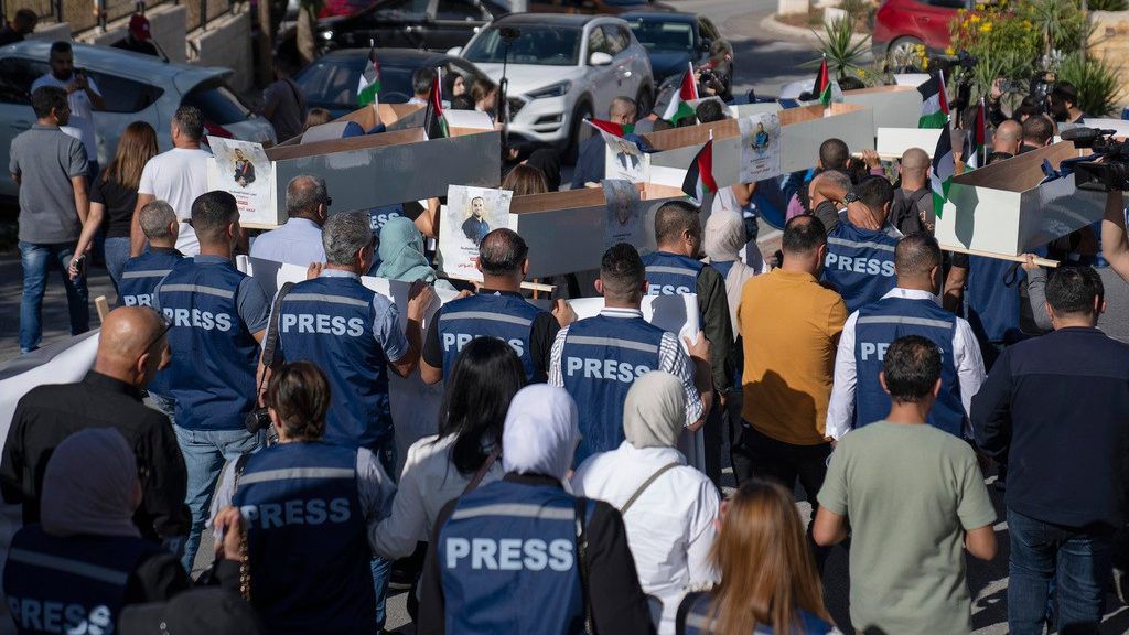 Palestinian journalists carry mock coffins of Palestinian journalists who were killed during the current war in Gaza during a symbolic funeral toward a United Nations office, in the West Bank city of Ramallah, Tuesday, Nov. 7, 2023. (AP Photo/Nasser Nasser)