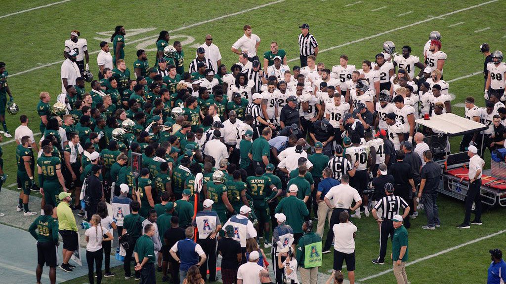 UCF and USF players gather around McKenzie Milton as he's seen by medical staff at Friday night's War on I-4 game. (Chris Torello, Spectrum News)