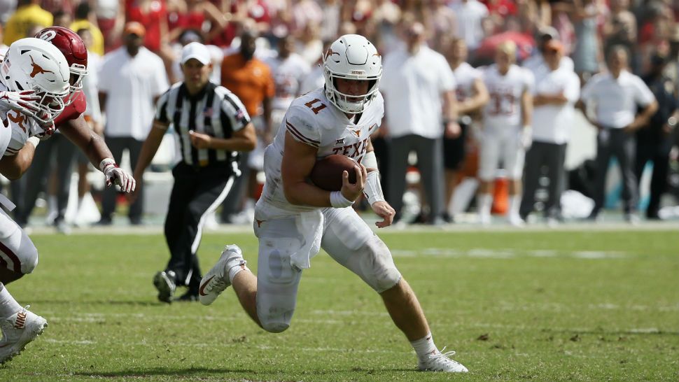 Texas Longhorns quarterback Sam Ehlinger looks for room to run during the second half of an NCAA college football game against the Oklahoma Sooners, Saturday, Oct. 6, 2018, in Dallas, Texas. (AP Photo/Roger Steinman)