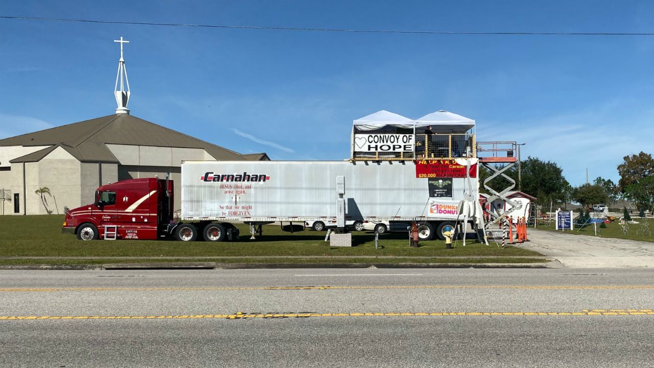 Carson Rudy and his father, Shawn, plan to spend the Thanksgiving holiday on top of a semi parked in front of their Lake Wales church to raise money for a humanitarian group. (Stephanie Claytor/Spectrum News)