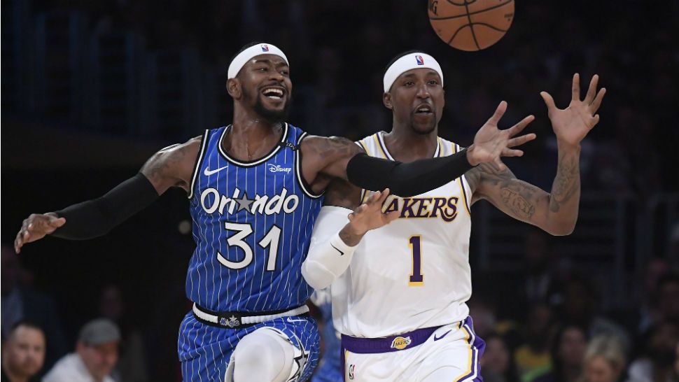 Orlando Magic guard Terrence Ross, left, and Los Angeles Lakers guard Kentavious Caldwell-Pope reach for a loose ball during the first half of an NBA basketball game Sunday, Nov. 25, 2018, in Los Angeles. (AP Photo/Mark J. Terrill)