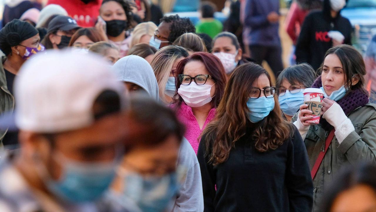 Black Friday shoppers wearing face masks wait in line to enter a store at the Citadel Outlets in Commerce, Calif., Nov. 26, 2021. (AP Photo/Ringo H.W. Chiu)