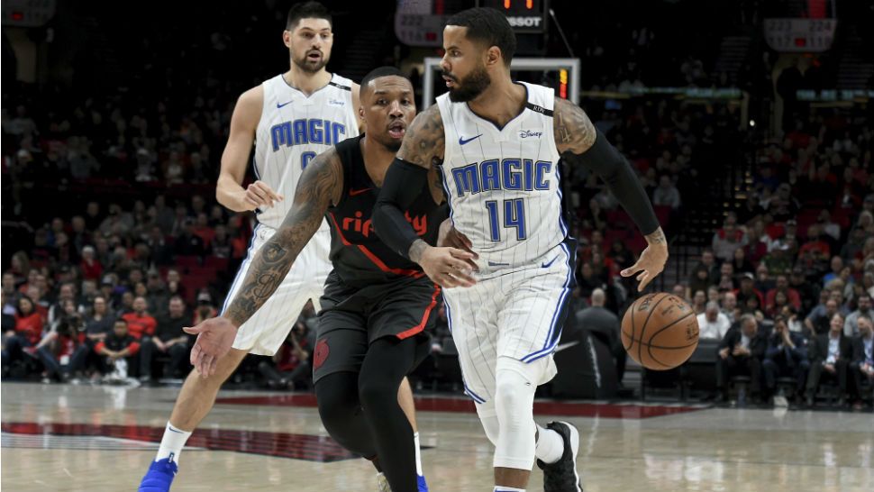 Orlando Magic guard D.J. Augustin, right, passes the ball behind his back to guard Evan Fournier, back left, as Portland Trail Blazers guard Damian Lillard, center, defends during the first half of an NBA basketball game in Portland, Ore., Wednesday, Nov. 28, 2018. (AP Photo/Steve Dykes)
