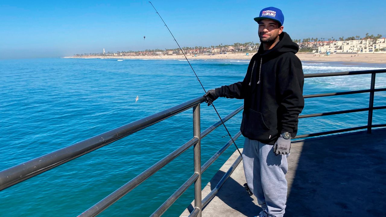 Michael Archouletta, 29, said he came down to Huntington Beach from East Los Angeles early to fish and didn't see any signs barring him from fishing on the pier in Huntington Beach, Calif., Sunday, Oct. 10, 2021. (AP Photo/Amy Taxin)