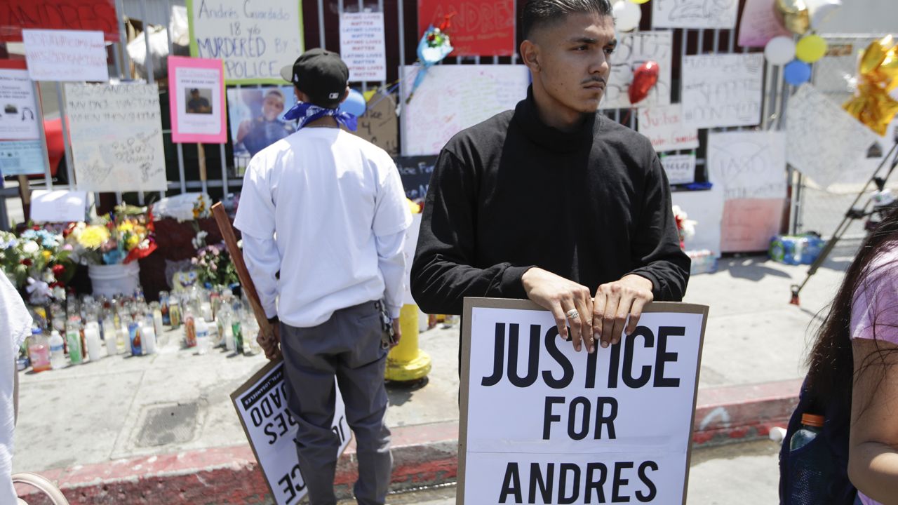 A protester holds a sign during a march in honor of Andres Guardado, Sunday, June 21, 2020, in Gardena, Calif. (AP Photo/Marcio Jose Sanchez)