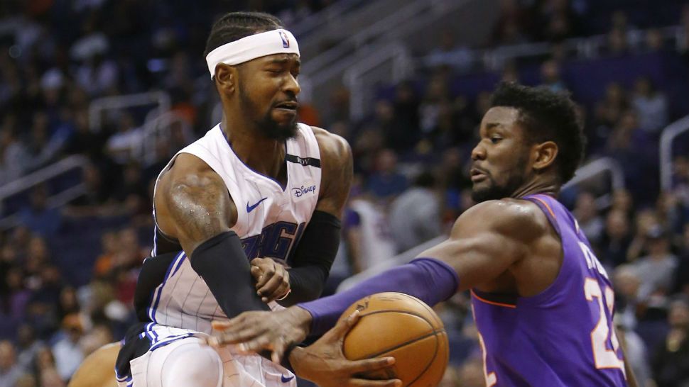 Orlando Magic guard Terrence Ross passes the ball around Phoenix Suns center Deandre Ayton (22) during the first half of an NBA basketball game Friday, Nov. 30, 2018, in Phoenix. (AP Photo/Rick Scuteri)