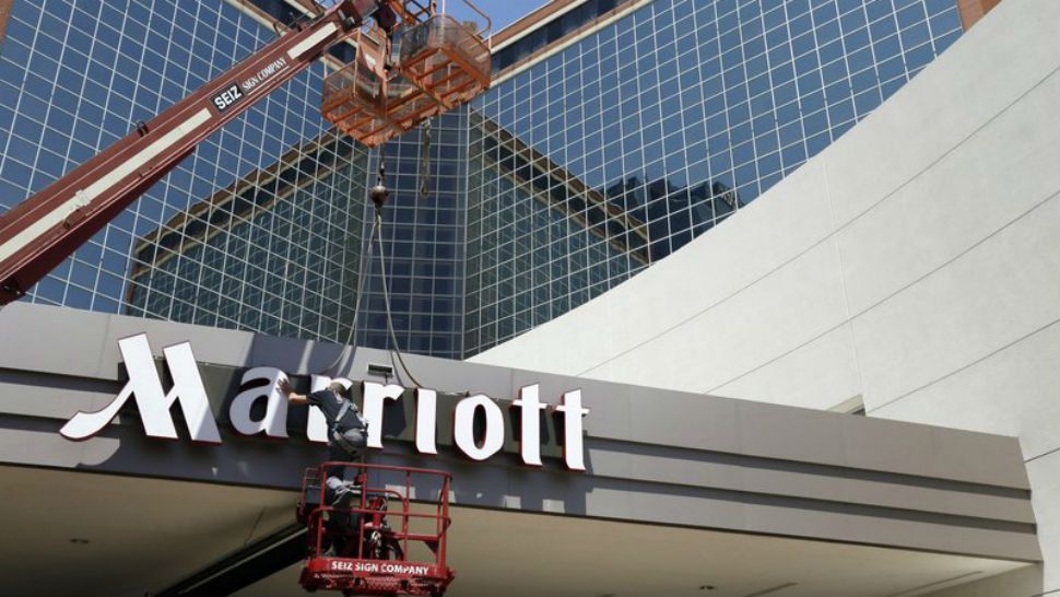 FILE - In this Tuesday, April 30, 2013, file photo, a man works on a new Marriott sign in front of the former Peabody Hotel in Little Rock, Ark. Marriott says the information of up to 500 million guests at its Starwood hotels has been compromised. It said Friday, Nov. 30, 2018, that there was a breach of its database in September, but also found out through an investigation that there has been unauthorized access to the Starwood network since 2014. (AP Photo/Danny Johnston, File)