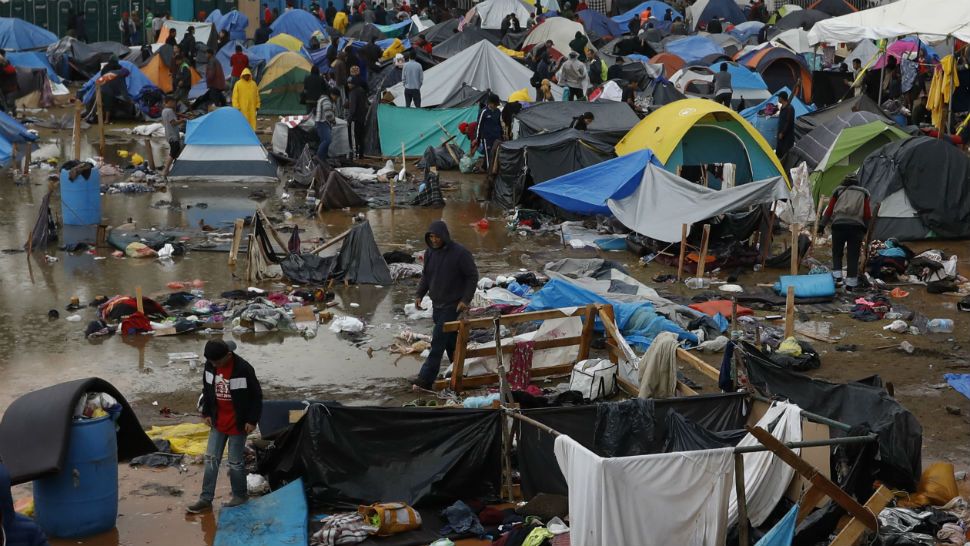Migrants walk amidst flooded tents after heavy rains poured down on a sports complex sheltering thousands of Central Americans, in Tijuana, Mexico, Thursday, Nov. 29, 2018. Aid workers and humanitarian organizations expressed concerns Thursday about the unsanitary conditions at the sports complex in Tijuana where more than 6,000 Central American migrants are packed into a space adequate for half that many people and where lice infestations and respiratory infections are rampant.(AP Photo/Rebecca Blackwell)