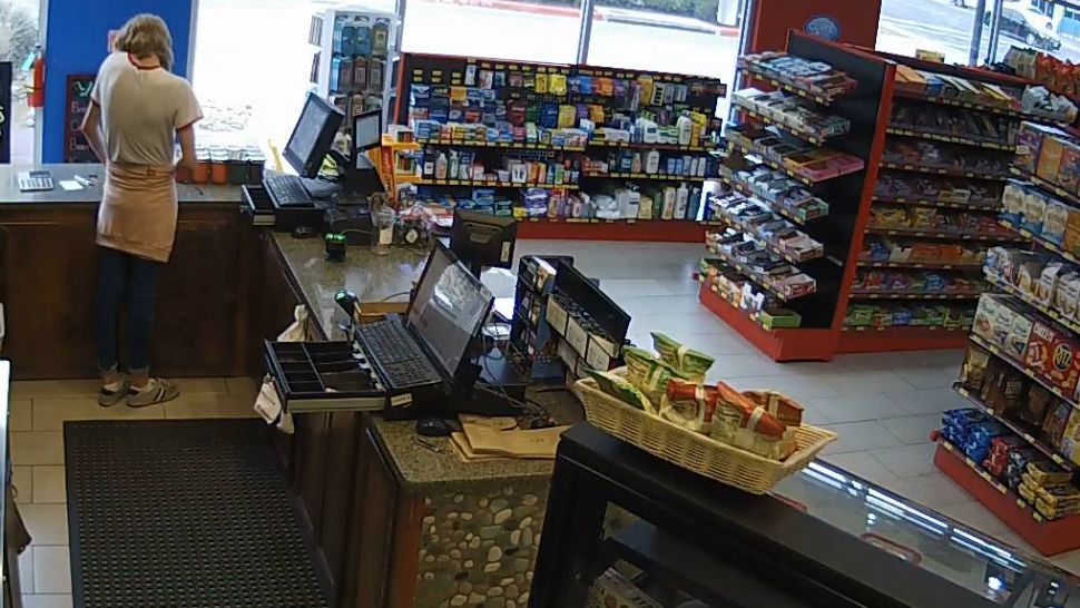 An employee behind the register of Midtown Grocery & Cafe in Austin (APD Surveillance Video Screenshot)