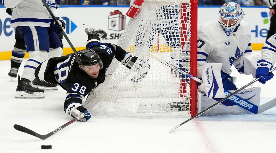 Tampa Bay Lightning left wing Brandon Hagel (38) falls into the goal while chasing the puck behind Toronto Maple Leafs goaltender Joseph Woll (60) during the second period of an NHL hockey game Saturday, Nov. 30, 2024, in Tampa, Fla. (AP Photo/Chris O'Meara)