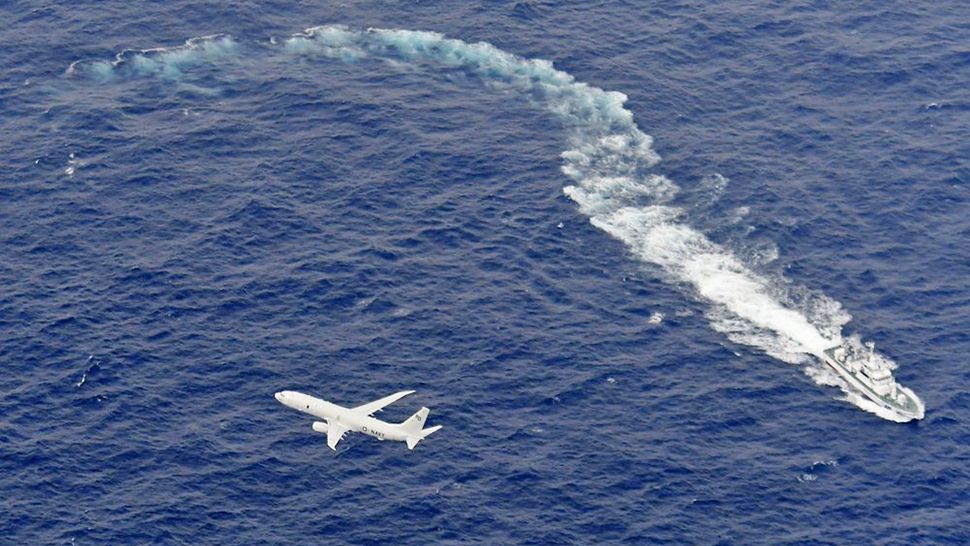In this Dec. 6, 2018, file photo, Japan's Coast Guard ship, top, and U.S. military plane are seen at sea off Kochi, southwestern Japan, during a search and rescue operation for missing crew members of a U.s. Marine refueling plane and fighter jet. The U.S. Marine Corps have declared that five crewmembers dead after their aircraft crashed last week off Japan's southern coast and that their search has ended. (Kyodo News via AP, file)
